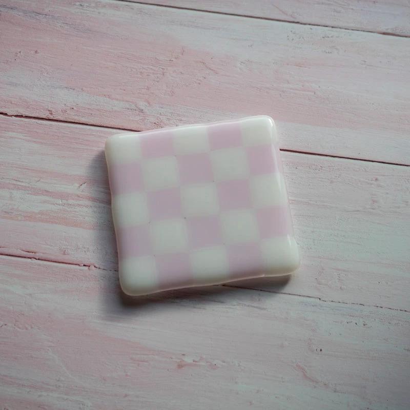 Pink and white checkered glass coaster on pastel wooden surface, handmade British craft