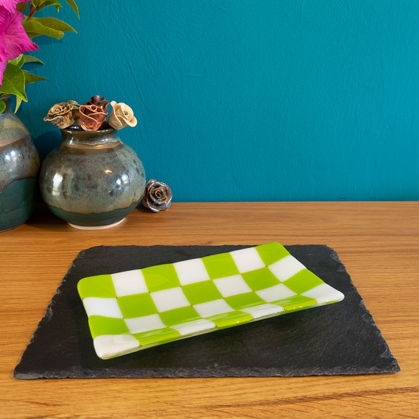 Green and white checkered glass tray on slate, styled with ceramic vase and flowers
