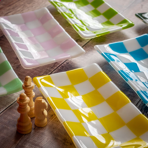 Colorful checkered ceramic trays with chess pieces on rustic wood — British handmade homeware